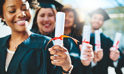 Buy stock photo Cropped shot of a group of students holding their diplomas on graduation day