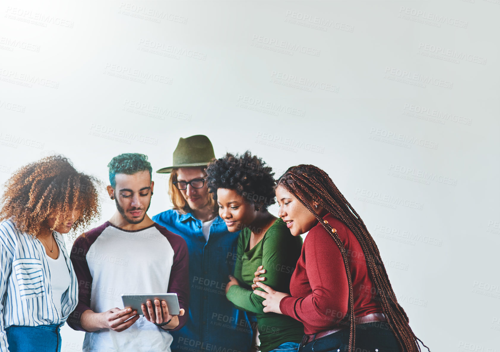 Buy stock photo Studio shot of a group of young people using a digital tablet together