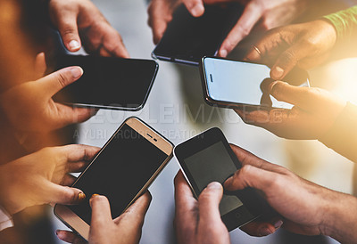 Buy stock photo Cropped shot of a group of people using their phones together
