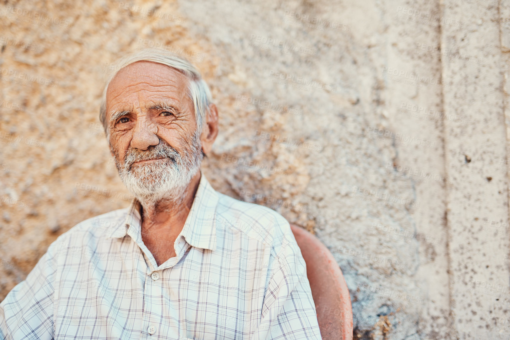 Buy stock photo Portrait of a senior man sitting outside on the sidewalk of an ancient city