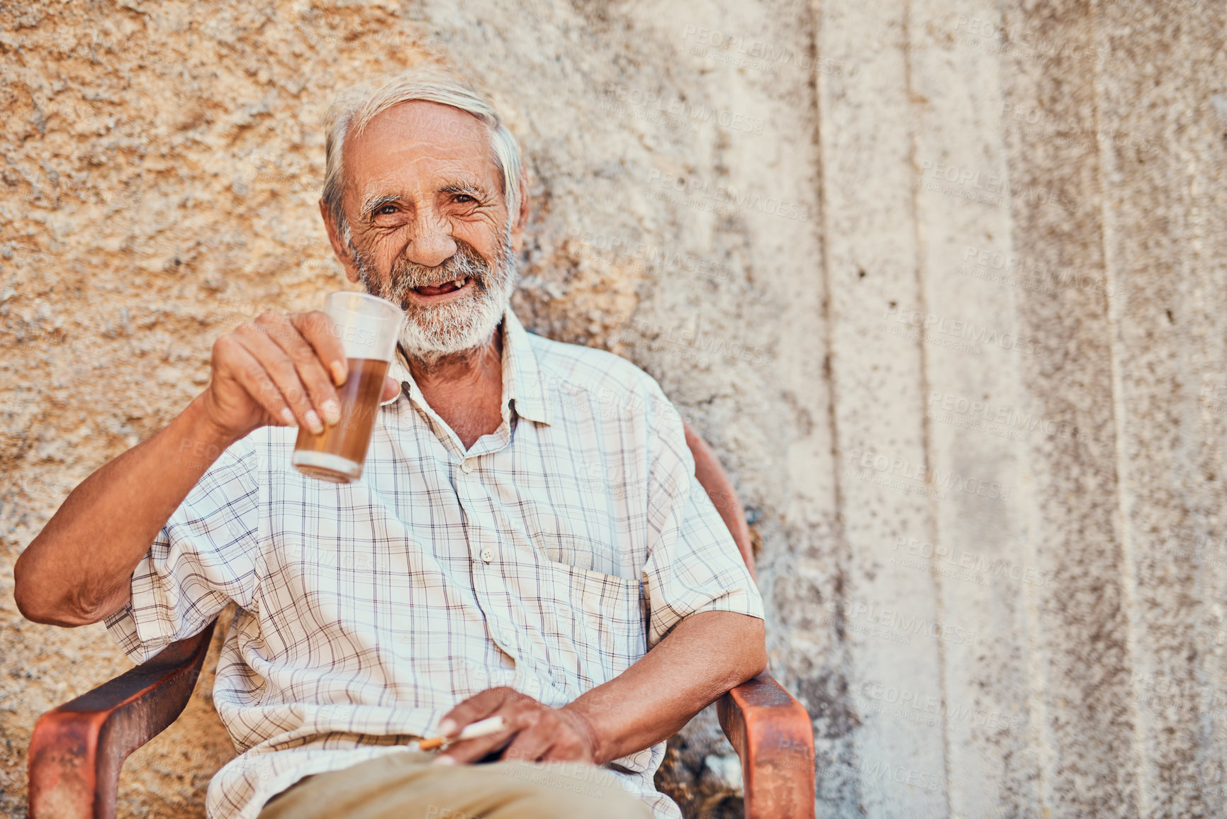 Buy stock photo Portrait of a senior man drinking and smoking outside on the sidewalk of an ancient city
