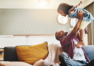 Buy stock photo Shot of an adorable little girl and her father playing together on the sofa at home