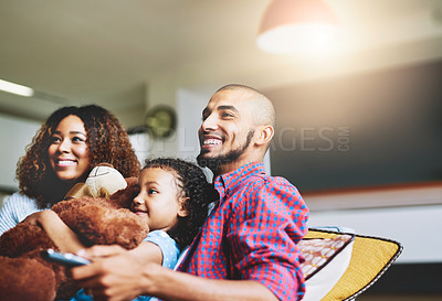 Buy stock photo Happy family, relax and watching tv with remote on sofa for comedy, movie or cartoon at home. Dad, mom and little girl with smile or parents for online streaming, subscription or funny entertainment