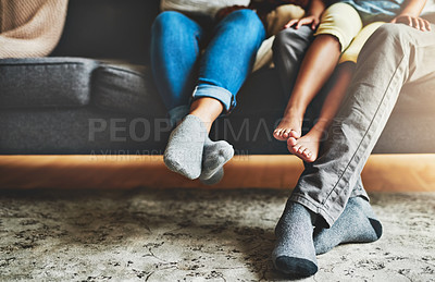 Buy stock photo Cropped shot of a family of three relaxing together on the sofa at home