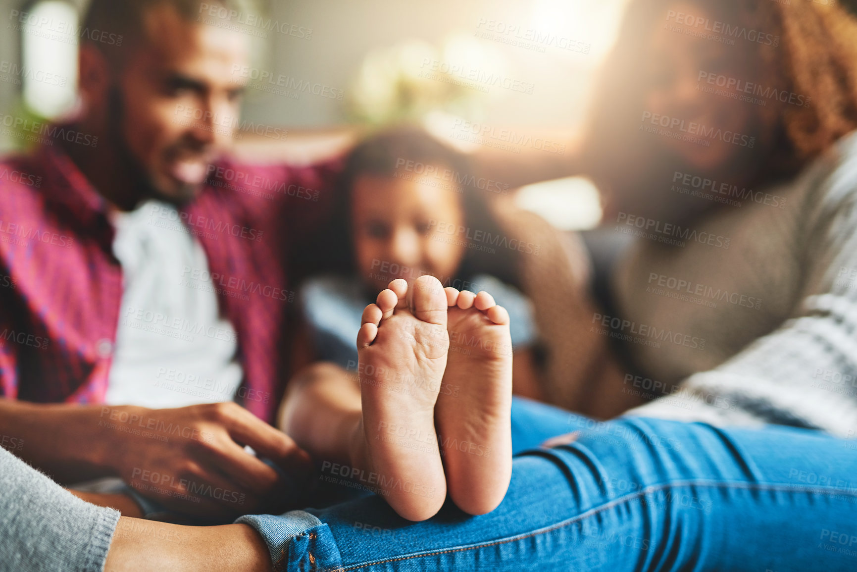 Buy stock photo Cropped shot of a family of three relaxing together on the sofa at home