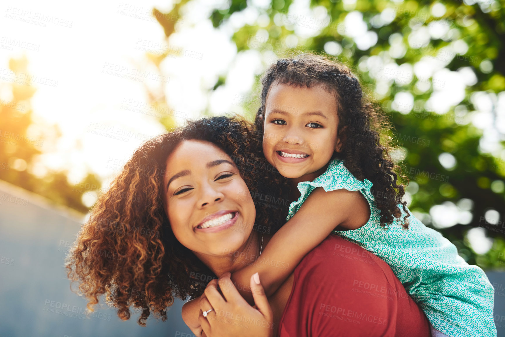 Buy stock photo Shot of a happy little girl and her mother enjoying a piggyback ride in their backyard