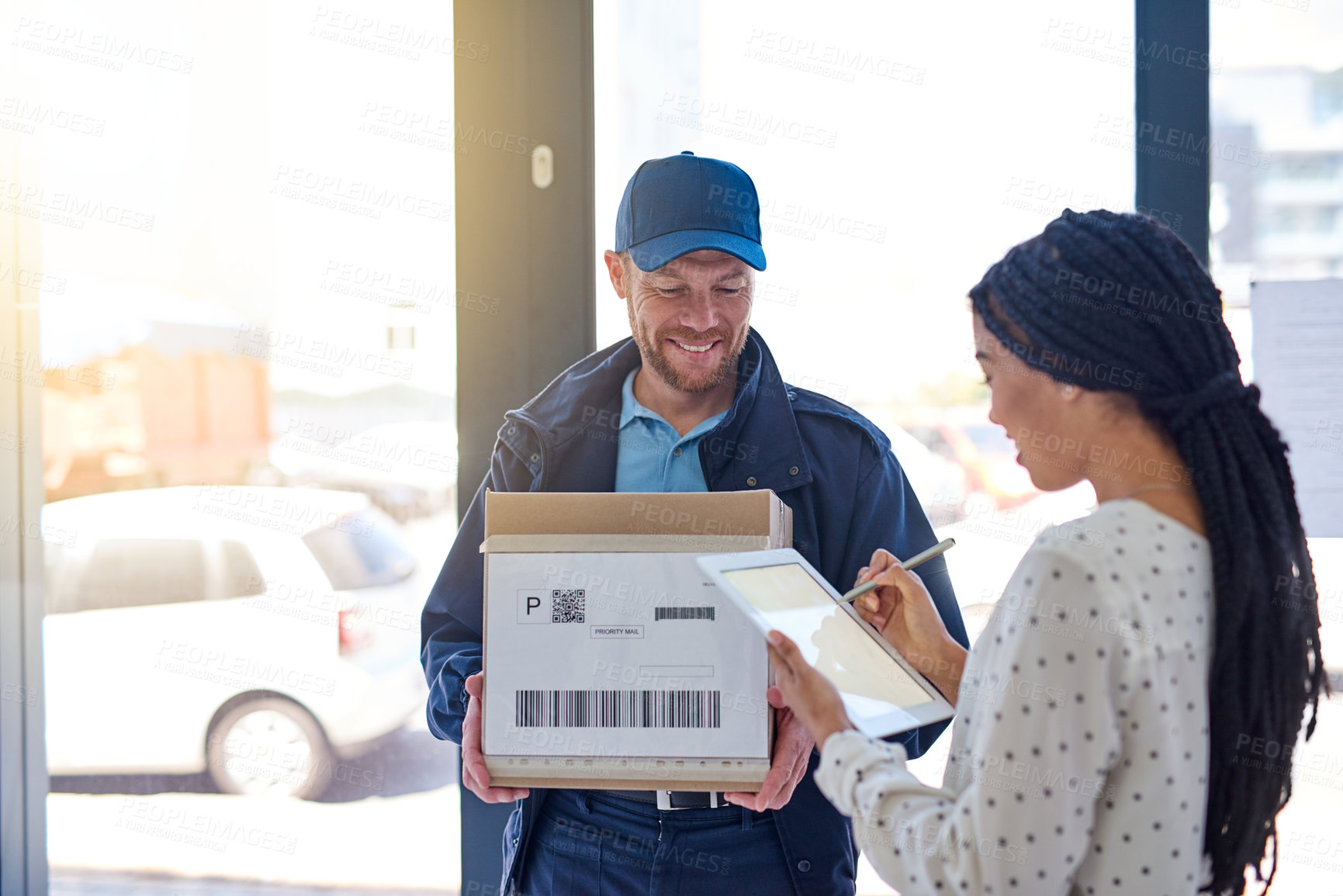 Buy stock photo Cropped shot of a handsome delivery man getting a signature from a female customer for her order