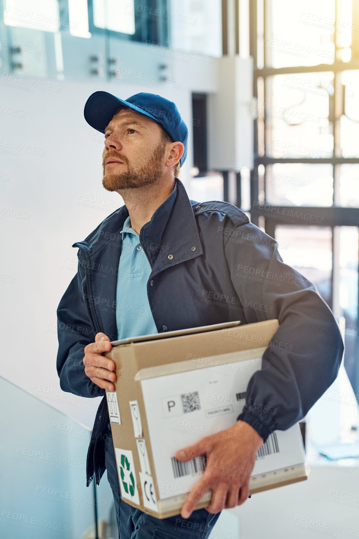 Buy stock photo Cropped shot of a handsome delivery man heading up a flight of stairs with a customer's order