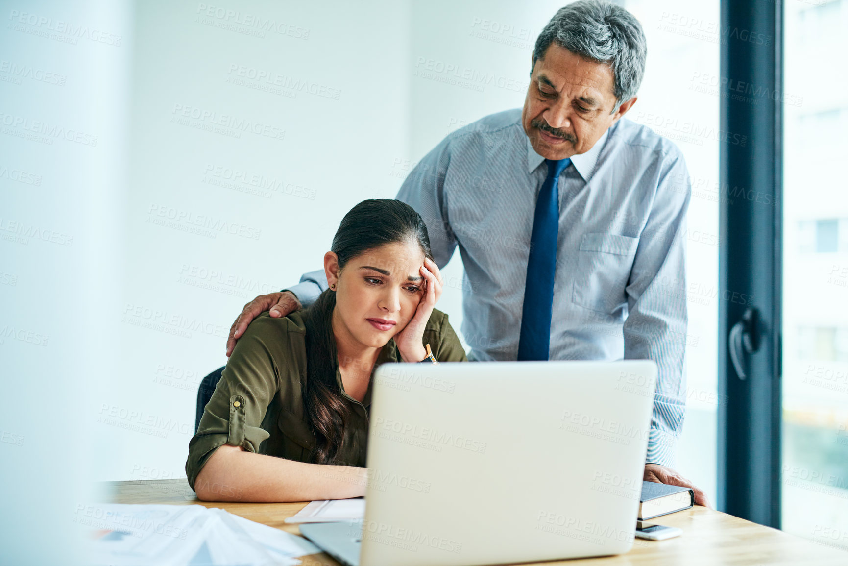 Buy stock photo Shot of a young businesswoman looking stressed out while a colleague tries to console her