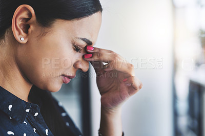 Buy stock photo Cropped shot of an attractive young businesswoman experiencing a headache in her office