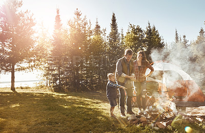 Buy stock photo Countryside, fire and child camping with parents in outdoor forest for vacation, holiday or adventure. Nature, bonding and kid with mother and father by flame and tent for weekend trip in Norway.