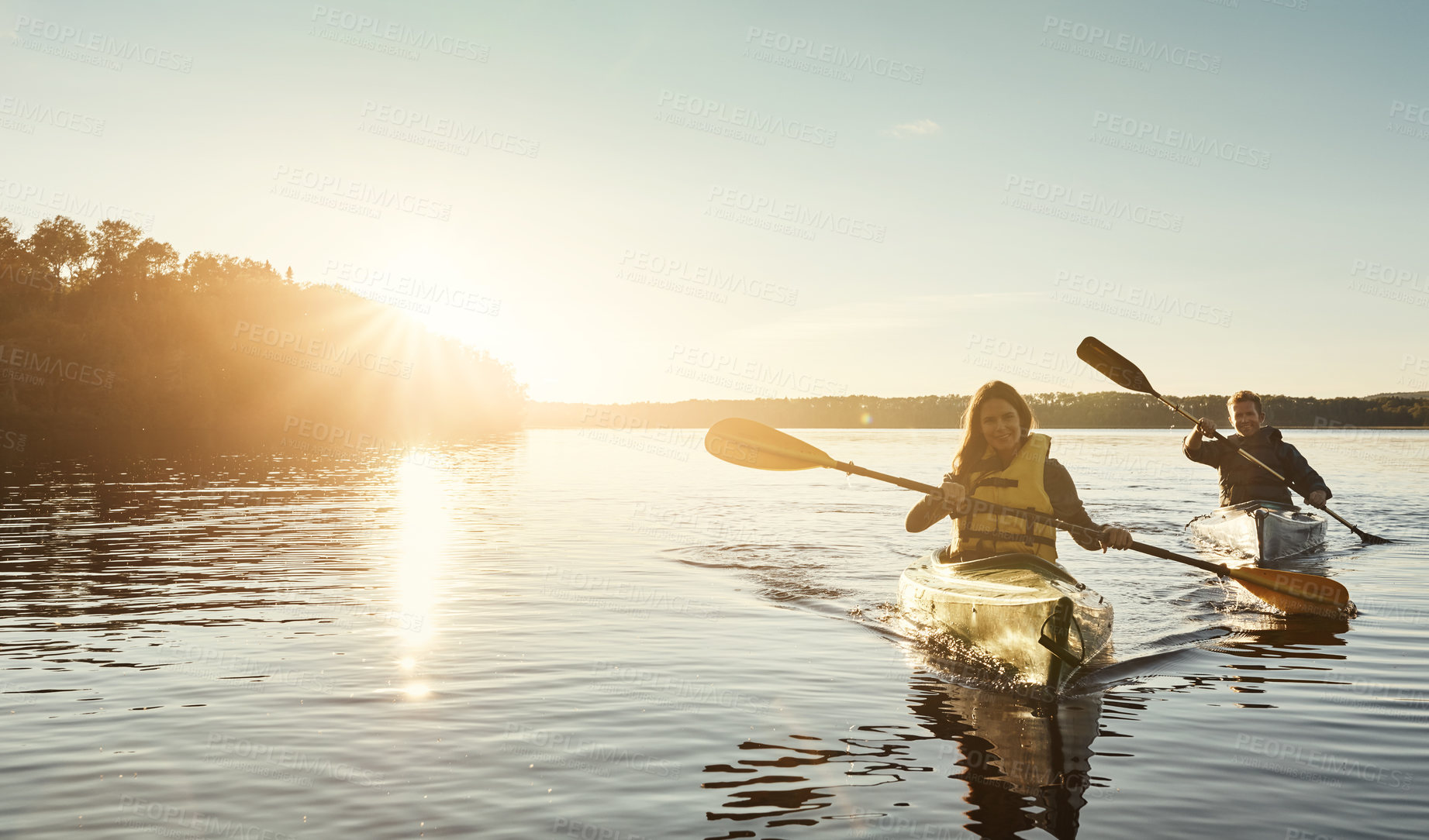 Buy stock photo Shot of a young couple kayaking on a lake outdoors