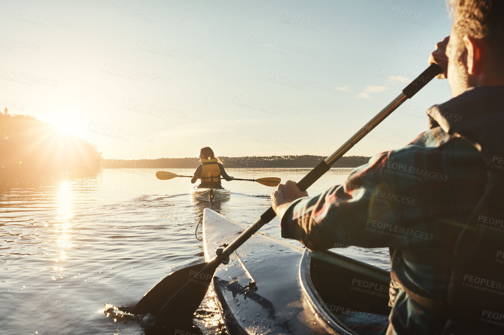 Buy stock photo Kayak, lake and people rowing a boat on the water during summer for recreation or leisure at sunset. Nature, view and horizon with people canoeing for adventure, freedom or travel while on vacation