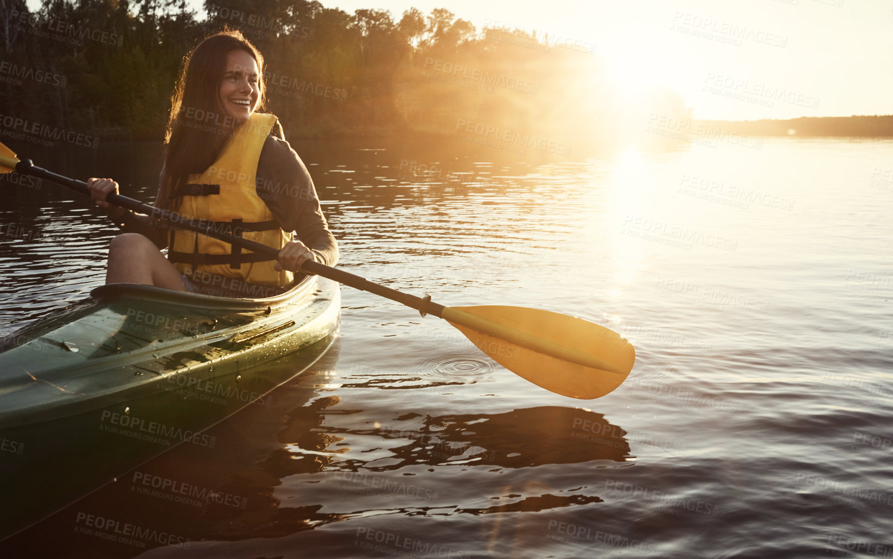 Buy stock photo Shot of a beautiful young woman kayaking on a lake outdoors