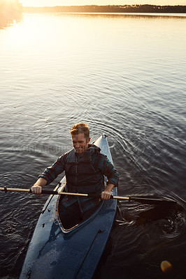 Buy stock photo High angle shot of a young man kayaking on a lake outdoors