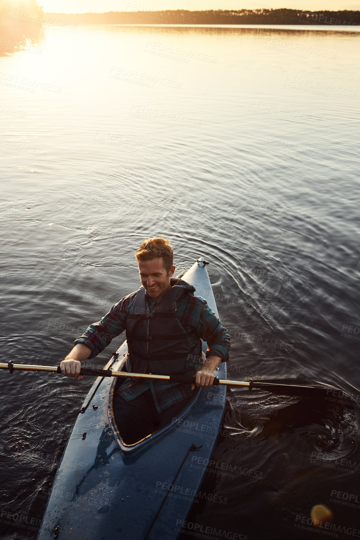 Buy stock photo High angle shot of a young man kayaking on a lake outdoors
