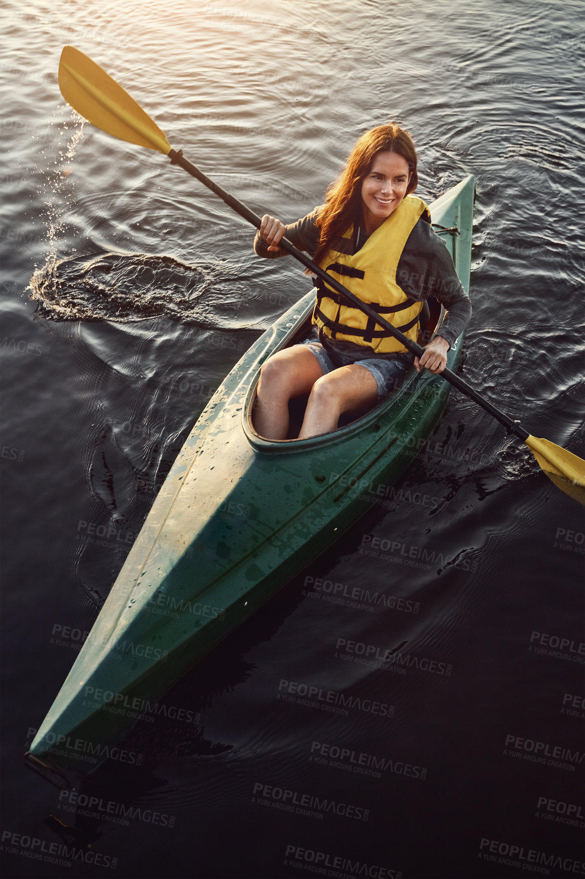 Buy stock photo High angle shot of a beautiful young woman kayaking on a lake outdoors