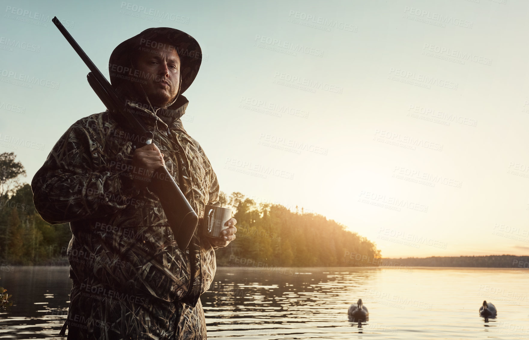 Buy stock photo Shot of a young man hunting duck while dressed in camo outdoors