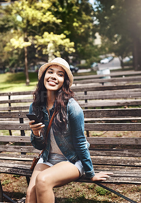 Buy stock photo Shot of an attractive young woman using a cellphone at the park