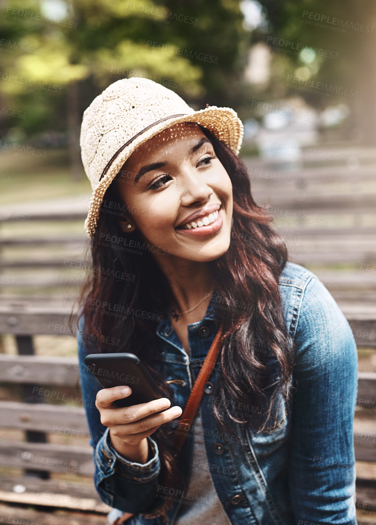 Buy stock photo Shot of an attractive young woman using a cellphone at the park