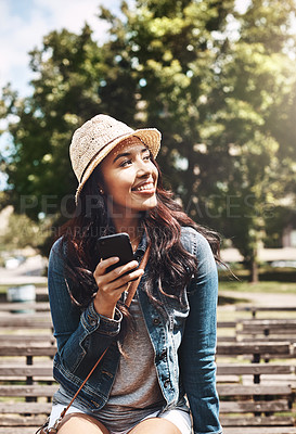 Buy stock photo Shot of an attractive young woman using a cellphone at the park