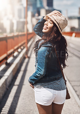 Buy stock photo Shot of a beautiful young woman looking over her shoulder while out for a walk