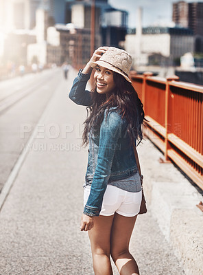 Buy stock photo Shot of a beautiful young woman looking over her shoulder while out for a walk