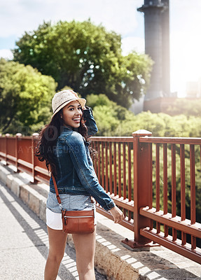 Buy stock photo Shot of a beautiful young woman looking over her shoulder while out for a walk