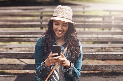 Buy stock photo Shot of an attractive young woman using a cellphone at the park