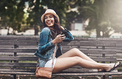 Buy stock photo Shot of an attractive young woman using a cellphone at the park