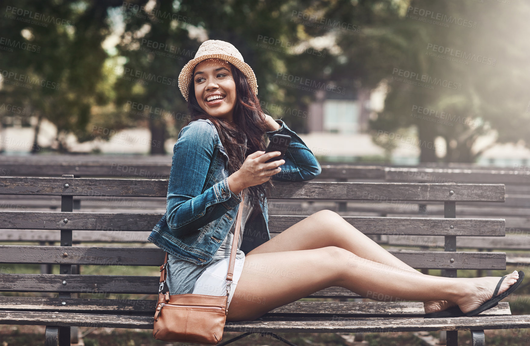 Buy stock photo Shot of an attractive young woman using a cellphone at the park