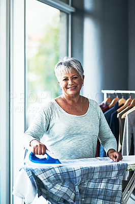 Buy stock photo Portrait of a mature woman ironing clothing at home