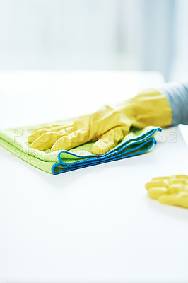 Buy stock photo Cropped shot of an unrecognizable person wearing rubber gloves and wiping a counter at home