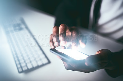Buy stock photo High angle shot of an unrecognizable man using a cellphone while working late in the office