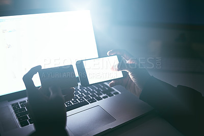 Buy stock photo High angle shot of an unrecognizable man doing some cellphone banking late at night in the office