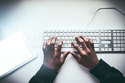 Buy stock photo High angle shot of an unrecognizable man typing on a keyboard while working late in the office