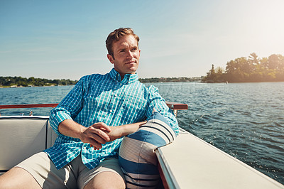 Buy stock photo Shot of a handsome young man spending the day on a private yacht