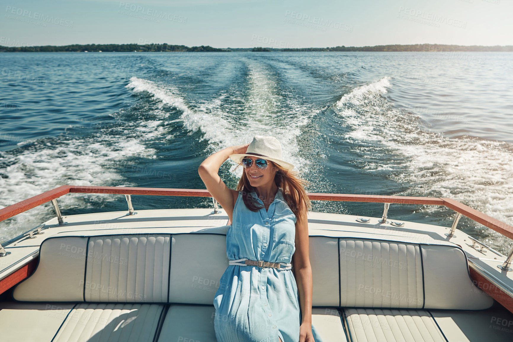Buy stock photo Shot of an attractive young woman spending the day on her private yacht