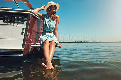 Buy stock photo Shot of an attractive young woman spending the day on her private yacht