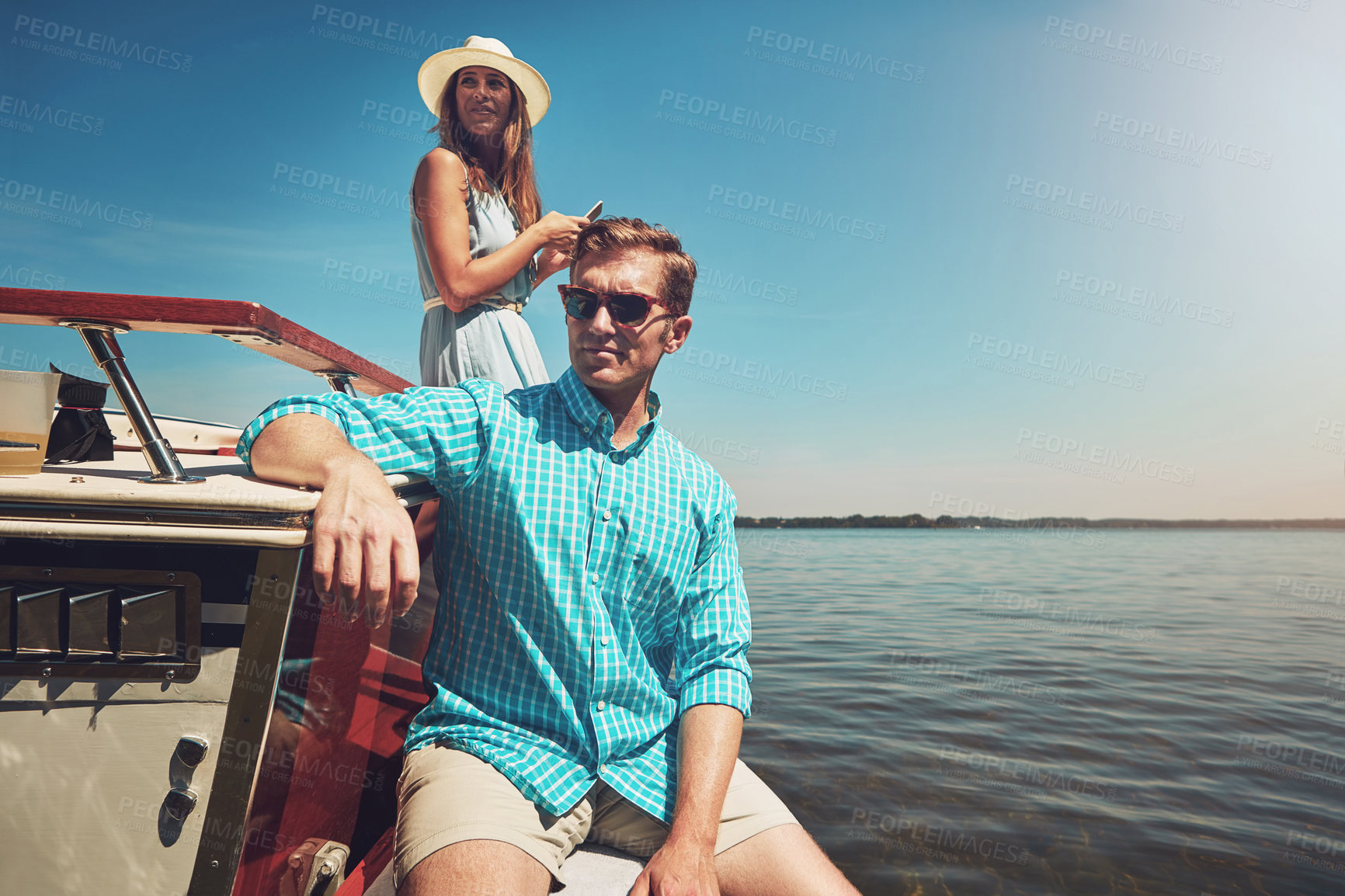 Buy stock photo Shot of a young couple going on a boat ride