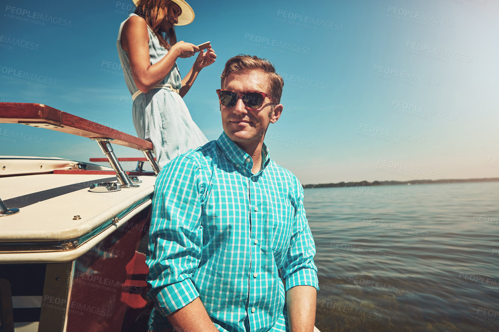 Buy stock photo Shot of a young couple going on a boat ride