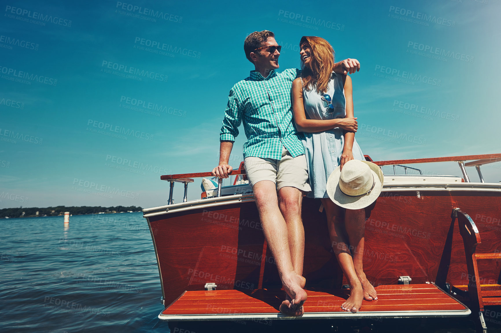Buy stock photo Shot of a young couple spending time together on a yacht