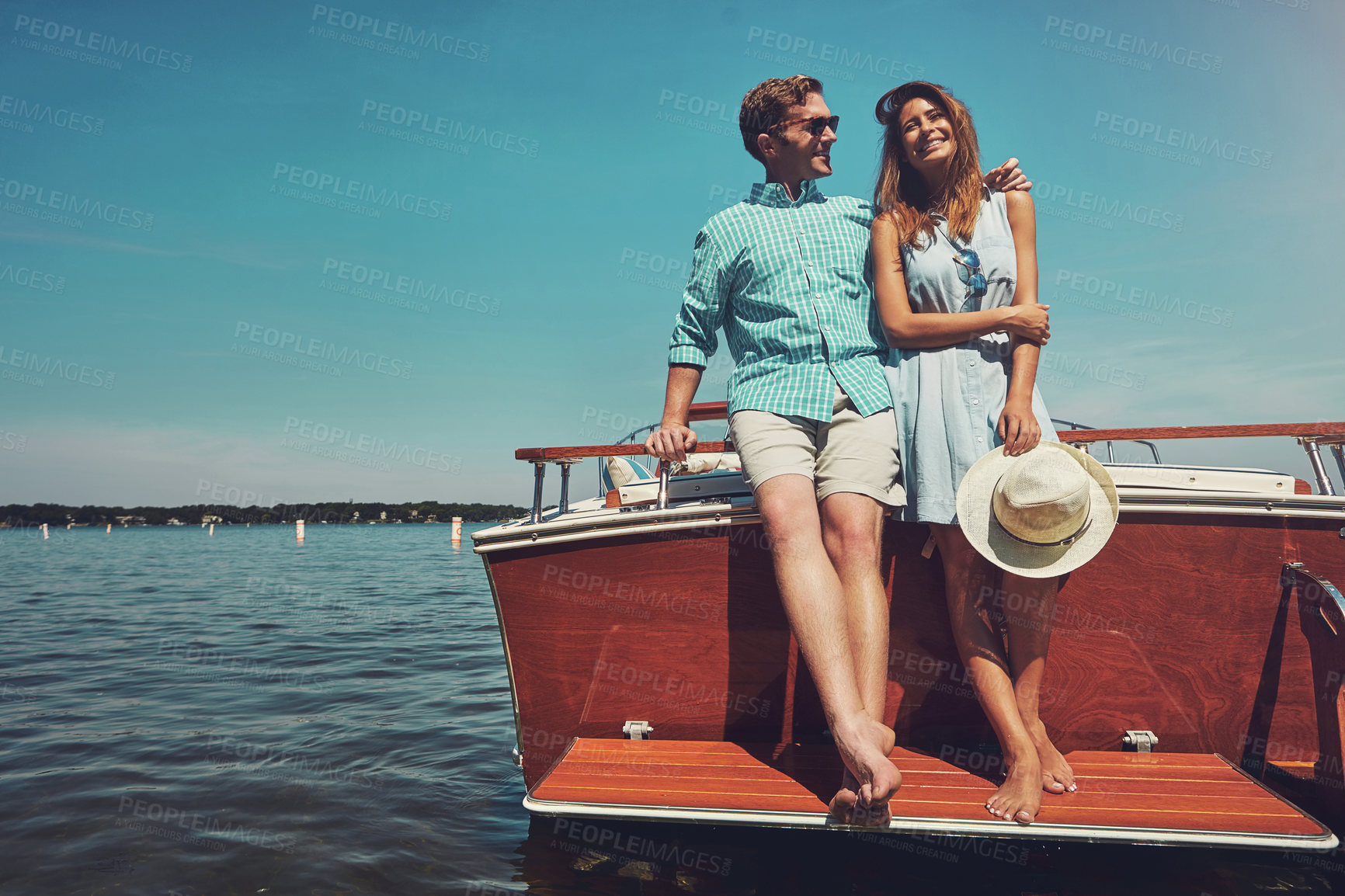 Buy stock photo Shot of a young couple spending time together on a yacht