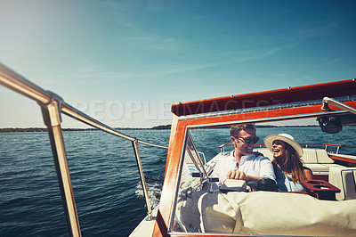 Buy stock photo Cropped shot of an affectionate young couple sailing on the open seas in their yacht