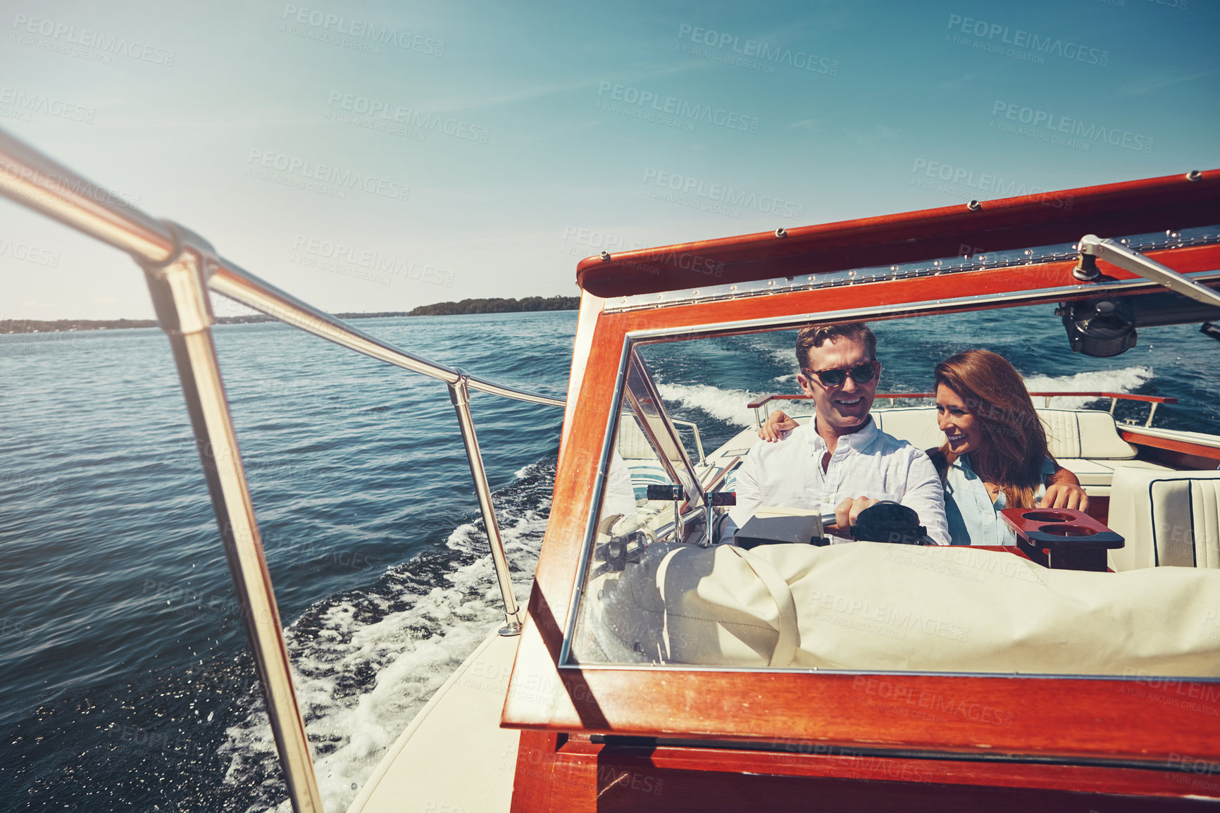 Buy stock photo Cropped shot of an affectionate young couple sailing on the open seas in their yacht