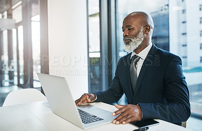 Buy stock photo Cropped shot of a mature businessman working on his laptop