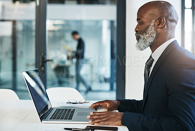 Buy stock photo Cropped shot of a mature businessman working on his laptop