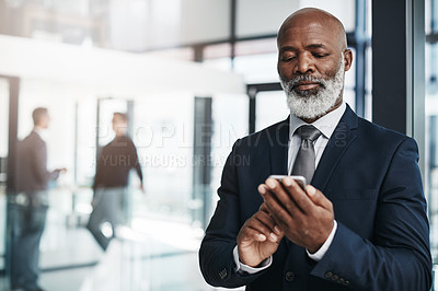 Buy stock photo Cropped shot of a mature businessman using his cellphone in an office