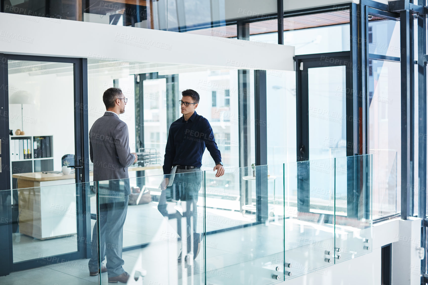 Buy stock photo Shot of two businessmen having a discussion in an modern office