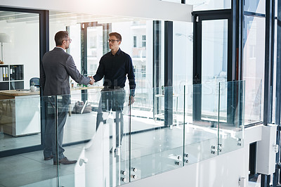 Buy stock photo Shot of two businessmen having a discussion in an modern office